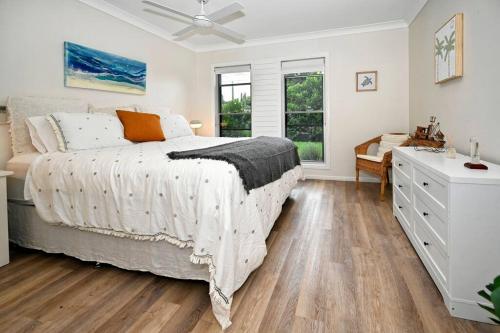 a white bedroom with a bed and a dresser at Golden Beach Family Relaxation in Golden Beach