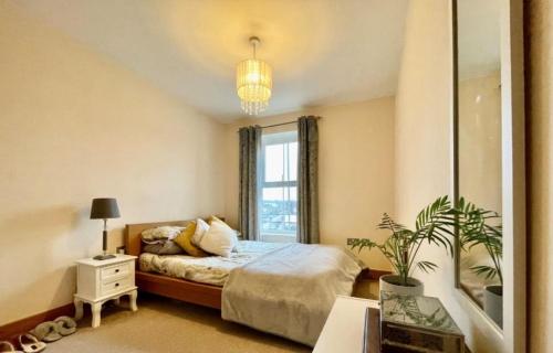 een slaapkamer met een bed en een groot raam bij Cosy 2 bedroom appartment with gated parking by River Thames in Kingston upon Thames