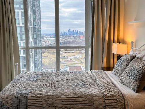 a bedroom with a large bed and a large window at 300 Front Suites - Two Beds with Free Parking in Toronto