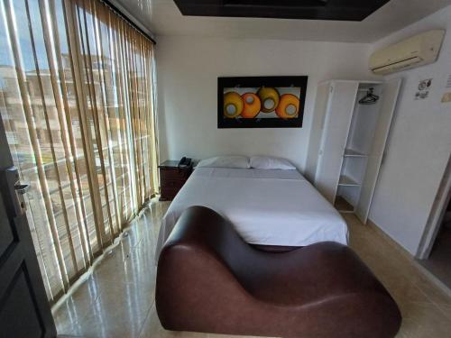 a bedroom with a bed and a chair in it at HOTEL DULCES SUEÑOS in Buenaventura