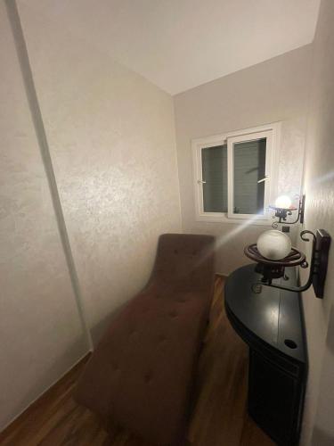 um pequeno quarto com uma cadeira e uma mesa em appartement moderne em Minaret de Mansuria