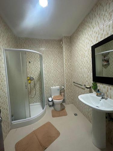 uma casa de banho com um chuveiro, um WC e um lavatório. em appartement moderne em Minaret de Mansuria