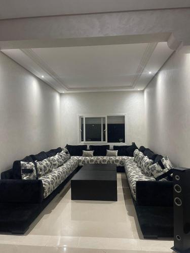 uma sala de estar com um sofá grande e uma mesa em appartement moderne em Minaret de Mansuria