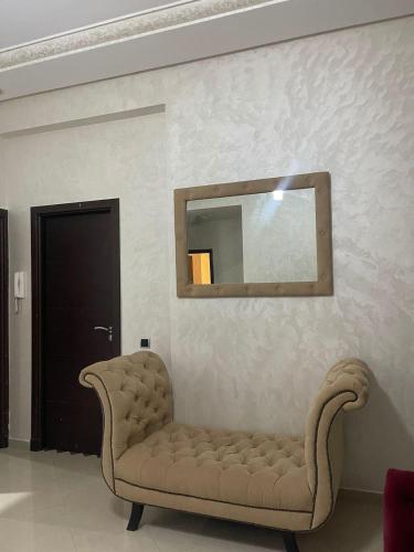 uma sala de estar com um sofá e um espelho em appartement moderne em Minaret de Mansuria