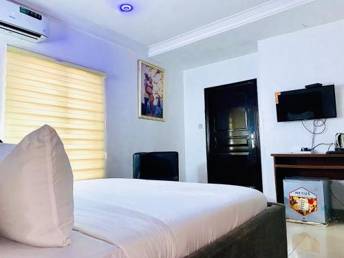 a bedroom with a bed and a desk and a television at Vintage Classic Suites in Lagos