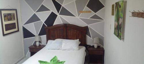 a bedroom with a bed with a geometric wall at Aracari Inn Mindo in Mindo