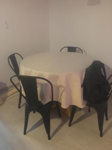 a table with two chairs and a white table cloth on it at Villa María in Villa María