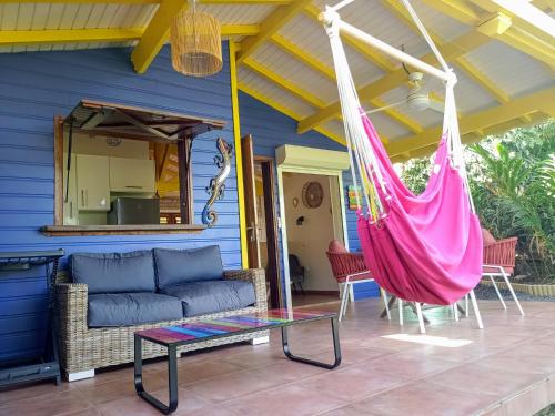 a hammock on the porch of a blue house at La Mare à Cuja in Sainte-Rose