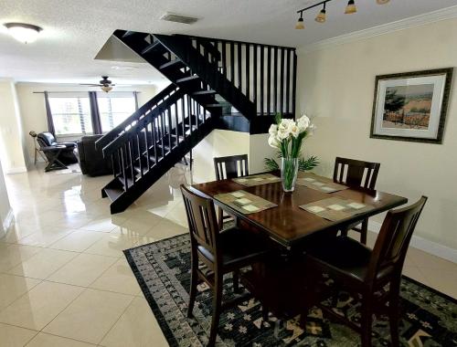 a dining room with a table and a staircase at Cozynest2 in Boynton Beach