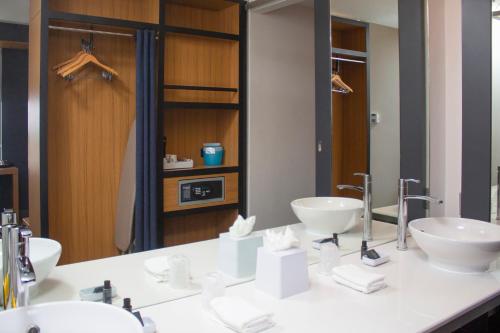 a bathroom with two sinks and a large mirror at Aloft Miami Doral in Miami