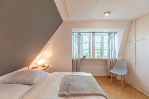 - une chambre avec un lit blanc et une fenêtre dans l'établissement Kastanienhof Hagebutte, à Wisch
