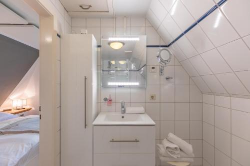 - une petite salle de bains avec un lavabo et un lit dans l'établissement Kastanienhof Hagebutte, à Wisch