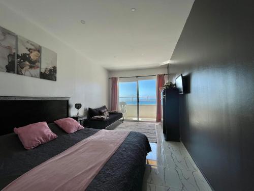 1 dormitorio con cama y vistas al océano en Riad Dar Naima Imsouane, en Imsouane