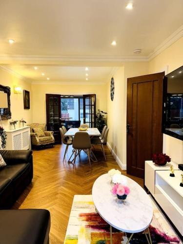 uma sala de estar com um sofá e uma mesa em Casa Marina- 4 bedroom house with garden and balcony em Golders Green