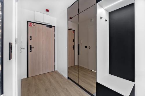 a hallway with a row of lockers and a mirror at Apartament Park Partynice in Wrocław