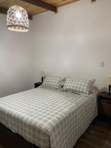 a bedroom with a bed with a checkered blanket at Portezuelo de árboles 