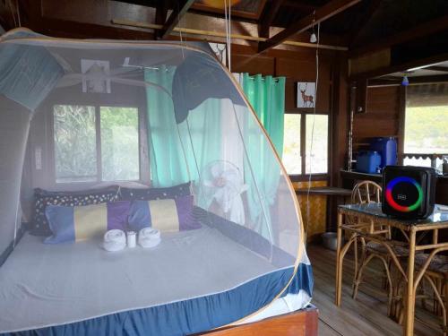 a bedroom with a canopy bed in a house at Just Inn2 beachfront in El Nido
