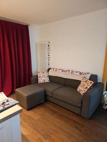 - un salon avec un canapé et un rideau rouge dans l'établissement casa vacanze Bondone, à Trente