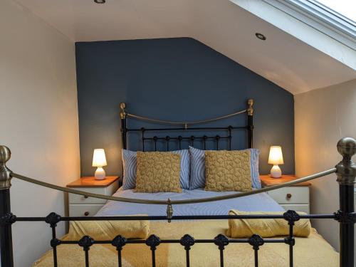 a bedroom with a black bed with two lamps at The Linhay in Bridport