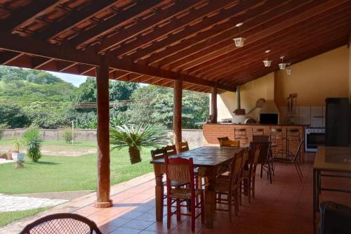 patio con mesa y sillas y cocina en Linda chácara no Itambé, en Ribeirão Preto