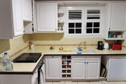 a kitchen with white cabinets and a sink at Villa Chill Sainte Anne in Sainte-Anne