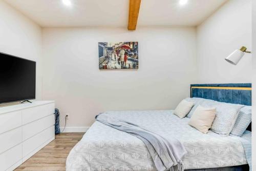 a bedroom with a bed and a flat screen tv at Adorable new studio with free parking and WiFi in Federal Way