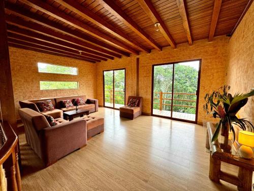 ein großes Wohnzimmer mit Sofas und Fenstern in der Unterkunft Wisdom Forest Lodge in Tena