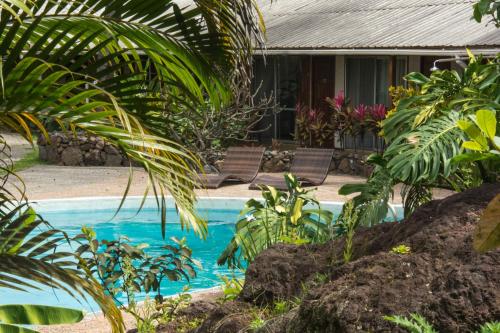 uma piscina em frente a uma casa com plantas em Hotel Hotu Matua em Hanga Roa