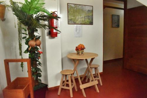una mesa pequeña y dos taburetes en una habitación en Suzet House, en Oxapampa