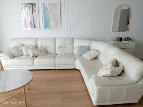 a white couch in a living room with a table at Alexandra on the Pacific in Mooloolaba