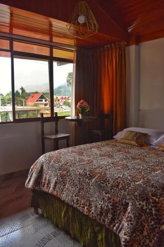 a bedroom with a bed and a large window at Suzet House in Oxapampa