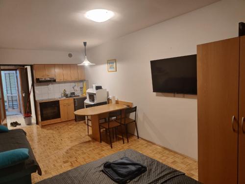 a living room with a table and a television on a wall at Apartma Luka with private parking in Izola