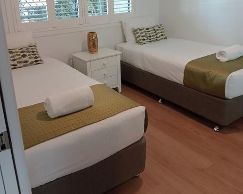 a bedroom with two beds and a window at Alexandra on the Pacific in Mooloolaba