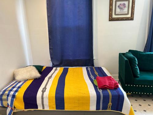 フィラデルフィアにあるPrivate roomのベッド(カラフルな毛布、緑の椅子付)