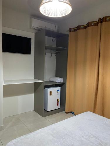 a room with a small kitchen with a small refrigerator at Pousada Brunetti in Penha