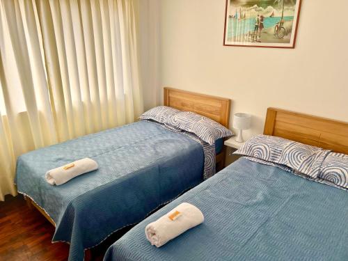 2 nebeneinander sitzende Betten in einem Schlafzimmer in der Unterkunft San Miguel, precioso depa 3 camas, internet y cable in Lima
