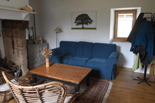 sala de estar con sofá azul y mesa en Rudelle maison de vacances en Rudelle