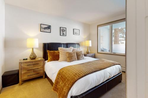 a bedroom with a bed and two lamps and a window at Seasons Lodge #101 in Edwards