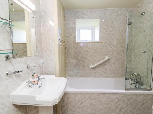 a bathroom with a sink and a shower and a tub at The Byre in Morpeth