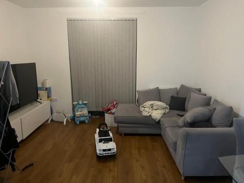 a living room with a gray couch and a white toy at Iron rail in Coulsdon