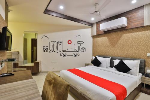 um quarto com uma cama e uma televisão e um carro na parede em Collection O Hotel Kia Residency em Bodakdev