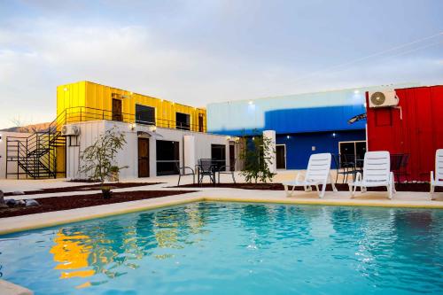 uma piscina em frente a um edifício com cadeiras em Vagón Resort em Cuatrociénegas de Carranza