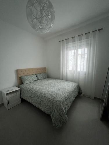 a white bedroom with a bed and a window at Lola in Gran Tarajal
