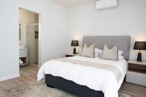 a bedroom with a large bed with white sheets and pillows at Atlantis Luxury Suites 3/4 in Swakopmund