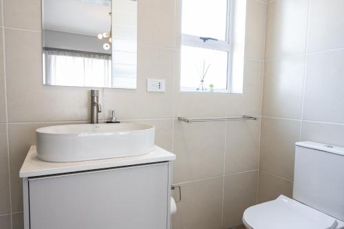 uma casa de banho branca com um lavatório e um WC em Atlantis Luxury Suites 3/4 em Swakopmund