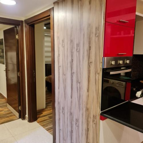 a kitchen with red cabinets and a stove at Quadro apartment in Amman
