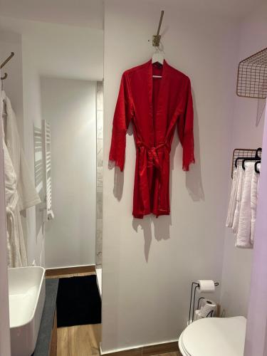 una giacca rossa appesa a un muro in bagno di Honey Room22 a Saint-Brieuc
