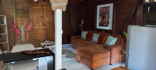 ein Wohnzimmer mit einem Sofa und einem Tisch in der Unterkunft LA ROSE DE CHAMP FLEURY in Labuthie
