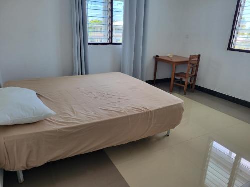 a bed in a room with a table and a chair at Chinese family kingdom in Nadi