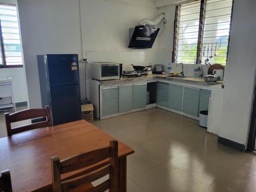 a kitchen with a blue refrigerator and a table in it at Chinese family kingdom in Nadi